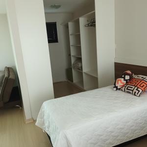 a bedroom with a white bed and a closet at Pousada Souza & Souza in Barra Velha