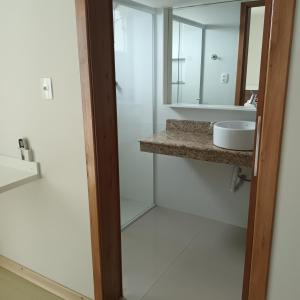 a bathroom with a sink and a mirror at Pousada Souza & Souza in Barra Velha