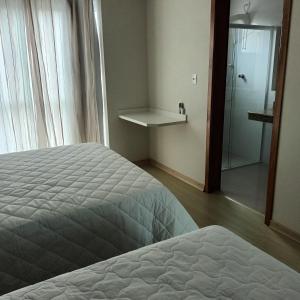 a bedroom with a bed and a walk in shower at Pousada Souza & Souza in Barra Velha