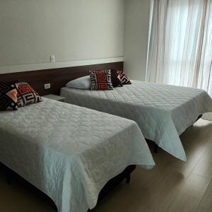 two beds sitting next to each other in a bedroom at Pousada Souza & Souza in Barra Velha