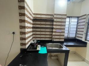 a small kitchen with a sink and a counter at The Lakeview Apart-Hotel in Agartala