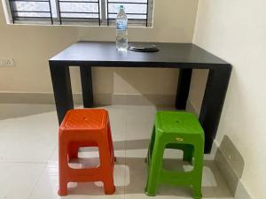 a table with a bottle of water and two stools at The Lakeview Apart-Hotel in Agartala