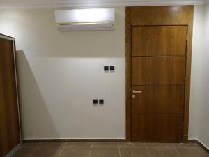 a hallway with a wooden door and a wall at Comfort Inn Al Taawon - Family Only in Riyadh