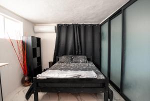 a bedroom with a bed with a black curtain at Studio B in Port Louis