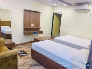 a hotel room with two beds and a tv at Hotel Royal Palace Gaya in Gaya