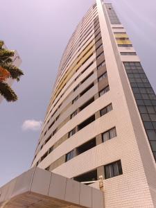 a tall building with a blue sky in the background at Suíte acolhedora em Hotel in Natal