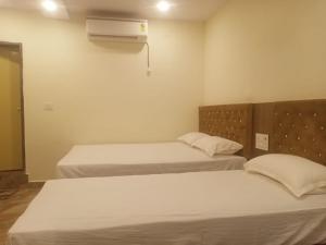 a bedroom with two beds and a air conditioner at Hotel Royal Palace Gaya in Gaya