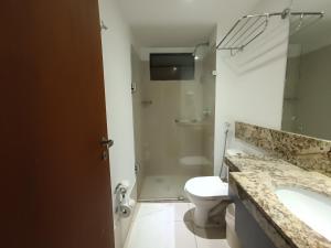 a bathroom with a toilet and a sink and a shower at Suíte acolhedora em Hotel in Natal