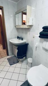 Baño blanco con lavabo y aseo en Apartment 61 Hannover, en Hannover