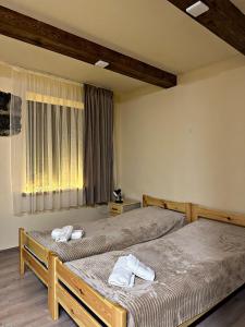 2 Einzelbetten in einem Zimmer mit Fenster in der Unterkunft Home-restaurant in Vanadzor in Wanadsor