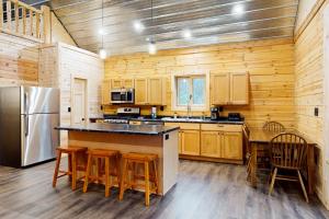 uma cozinha com armários de madeira e um frigorífico em Brown Bear Cabin em Tomahawk