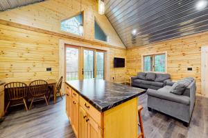 uma sala de estar em cabana de madeira com uma mesa e cadeiras em Brown Bear Cabin em Tomahawk