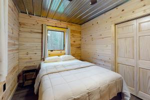 um quarto com uma cama num chalé de madeira em Brown Bear Cabin em Tomahawk