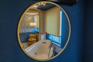 a bathroom with a tub in a round mirror at Ayramin Deluxe Hotel Taksim in Istanbul