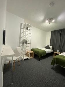 una habitación de hotel con 2 camas y un estante en Cold Harbour Entire 3 Bed House - Free Parking, en Croydon