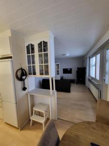 a kitchen and living room with a table and a refrigerator at Rivitaloasunto Kittilässä in Kittilä