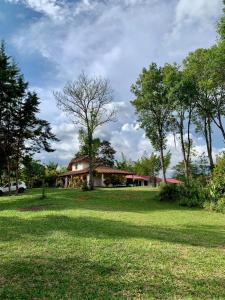 a house in the middle of a field with trees at HOSPEDAJE CAMPESTRE VILLA PARAISO in Curití