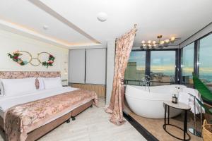 イスタンブールにあるアイラミン ホテル タクシムのベッドルーム(大型ベッド1台、バスタブ付)