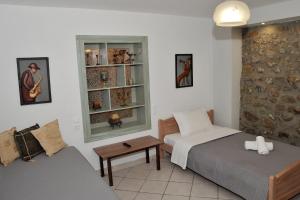 um quarto com 2 camas, um sofá e uma janela em Pavillion1 em Kalabaka
