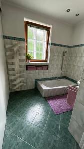 a bathroom with a tub and a window at hAUSzeit - Bungalow in Leoben +8 photos