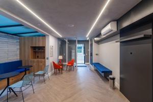 ein Wohnzimmer mit blauen Decken und orangefarbenen Stühlen in der Unterkunft 360 Praça da Árvore in São Paulo