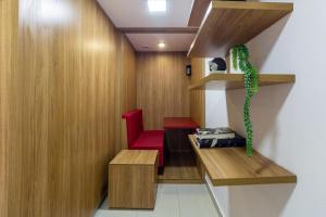 ein Wartezimmer mit einem roten Stuhl und einer Pflanze in der Unterkunft 360 Praça da Árvore in São Paulo