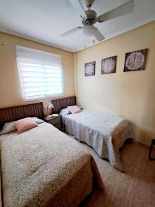 ラ・マタにあるApartament Via Marのシーリングファン付きのベッドルーム1室(ベッド2台付)
