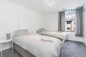 a white bedroom with a bed and a window at FOUNDRY - 2 Bedrooms, Fully Equipped, Free Parking, WiFi, FAVOURITE for Contractors, Long Stays Welcome, Food, Bars, Shops by Diamond Short Lets in Dunfermline
