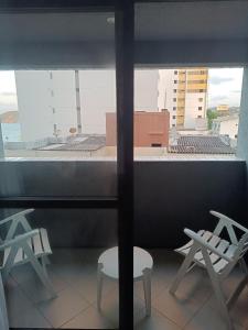 纳塔尔Flat com sacada a Beira-Mar的客房享有带椅子和窗户的景致。