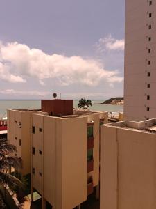 un grupo de edificios con el océano en el fondo en Flat com sacada a Beira-Mar, en Natal