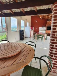 una mesa de madera y sillas en una habitación en Chácara Vale do Sol, en Pinhalzinho
