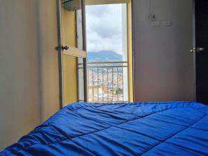 a bedroom with a blue bed and a window at apartamento con vista volcán in Pasto