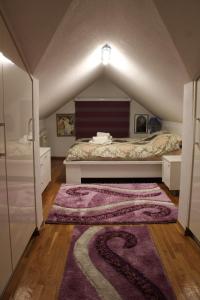 a attic bedroom with a bed and a rug at Apartman Bony M in Kiseljak