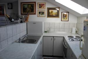 a white kitchen with a sink and a stove at Apartman Bony M in Kiseljak