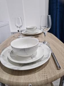 a table with plates and wine glasses on it at Manchester in Style: 1-Bed Oasis in Manchester