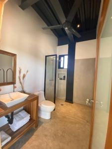 ein Bad mit einem WC, einem Waschbecken und einer Dusche in der Unterkunft Casa Balam in Placencia Village