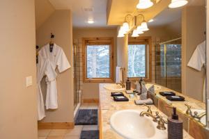 un bagno con due lavandini e un grande specchio di Walking distance to downtown Breck, Stunning ski resort panorama, hot tub, foosball, arcade machine! a Breckenridge Altre 36 foto