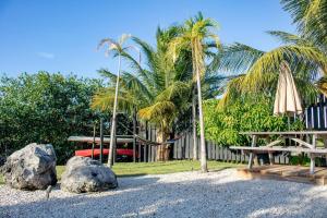 un parque infantil con hamaca, banco y palmeras en Casa Balam, en Placencia Village