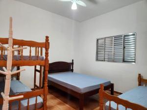 a bedroom with two bunk beds and a window at Casa no Centro 600m da Praia in Bertioga