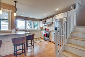 a kitchen with white cabinets and a bar with stools at Waterfront Lake Webb Cabin Rental with Dock and Views! 