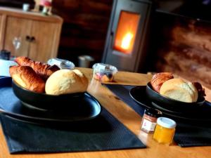 two plates of bread and croissants on a table at Chalet Amoureux (Région Durbuy) in Heure
