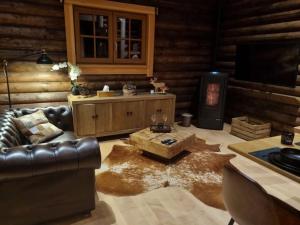 a living room with a leather couch and a coffee table at Chalet Amoureux (Région Durbuy) in Heure +23 photos