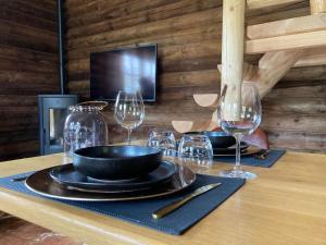 a table with plates and wine glasses on it at Chalet Amoureux (Région Durbuy) in Heure