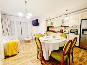 a kitchen and dining room with a table and chairs at Spacious 3 rooms 5* mansion near Muzeului square. Free parking in Cluj-Napoca