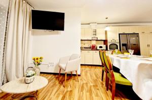 a kitchen and living room with a table and chairs at Spacious 3 rooms 5* mansion near Muzeului square. Free parking in Cluj-Napoca