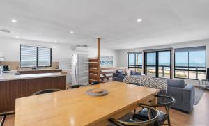 a kitchen and living room with a table and chairs at The Rise on Surfer- BEACHFRONT Pet Friendly WIFI in Middleton