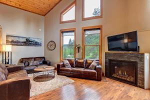 a living room with leather furniture and a fireplace at Gorgeous updated mountain home just minutes from the slopes, private hot tub, pool table! in Breckenridge