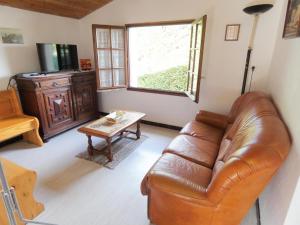 a living room with a leather couch and a coffee table at Le point du jour in Lit-et-Mixe