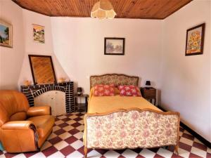 a bedroom with a bed and a chair at Le point du jour in Lit-et-Mixe