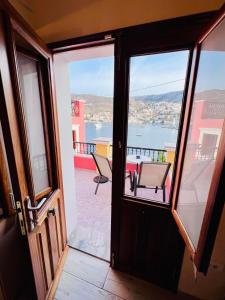 een deur naar een balkon met uitzicht op het water bij Kleanthi and Kostas Studios in Symi